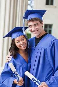 two graduates in medium blue robes and caps for poem graduation